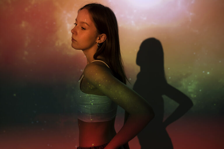 Femme entourée de lumières de l'univers symbolisant le coaching de vie quantique et la transformation personnelle